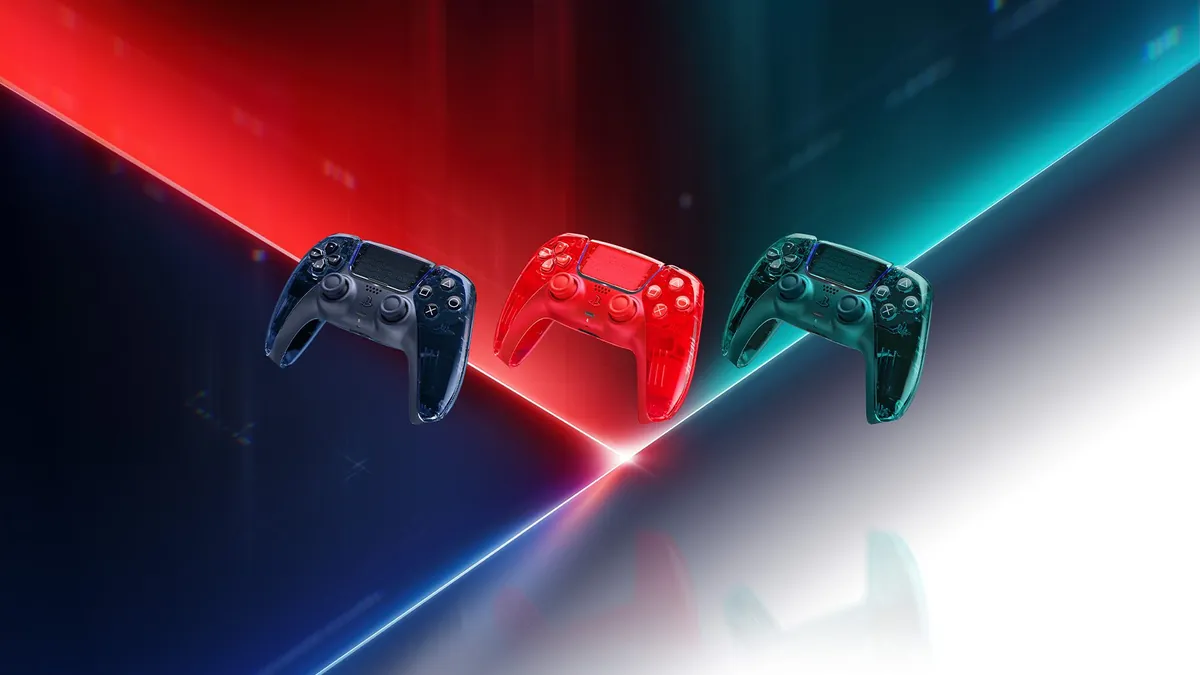 Three transparent DualSense controllers in grey, orange and green on a white and blue background